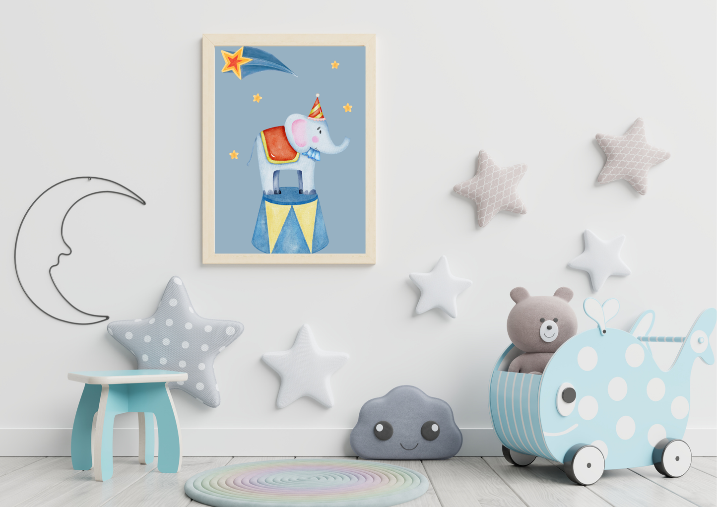 Children's room with a framed picture of an elephant, star decorations, and toys on a light blue wall.
