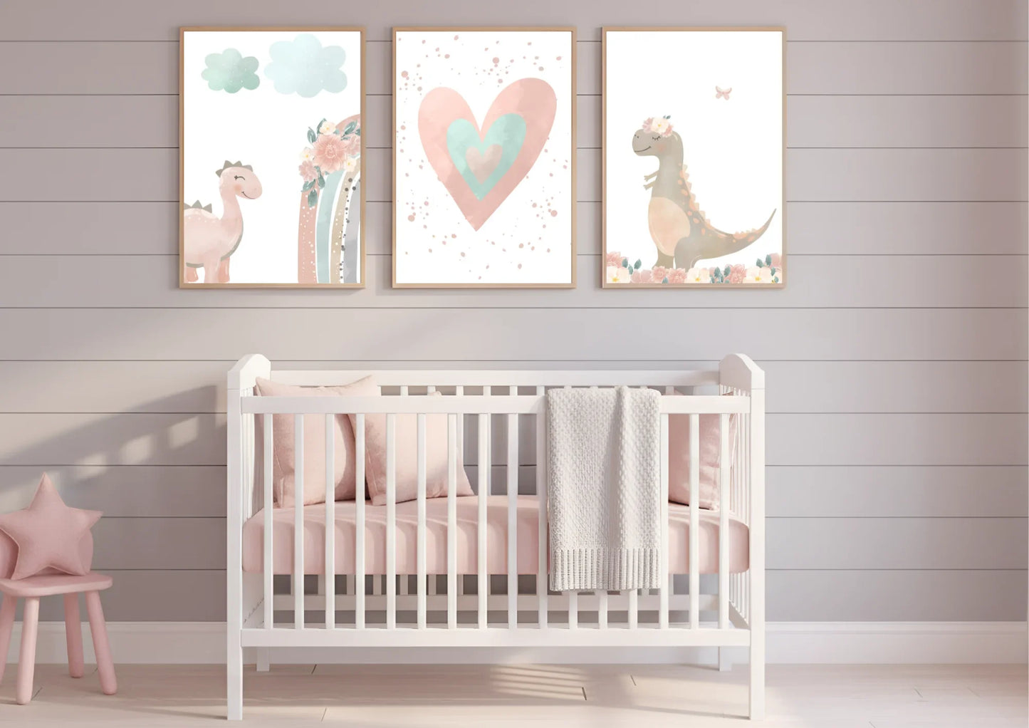 Nursery room with a white crib, pink chair, and three framed dinosaur prints on the wall.