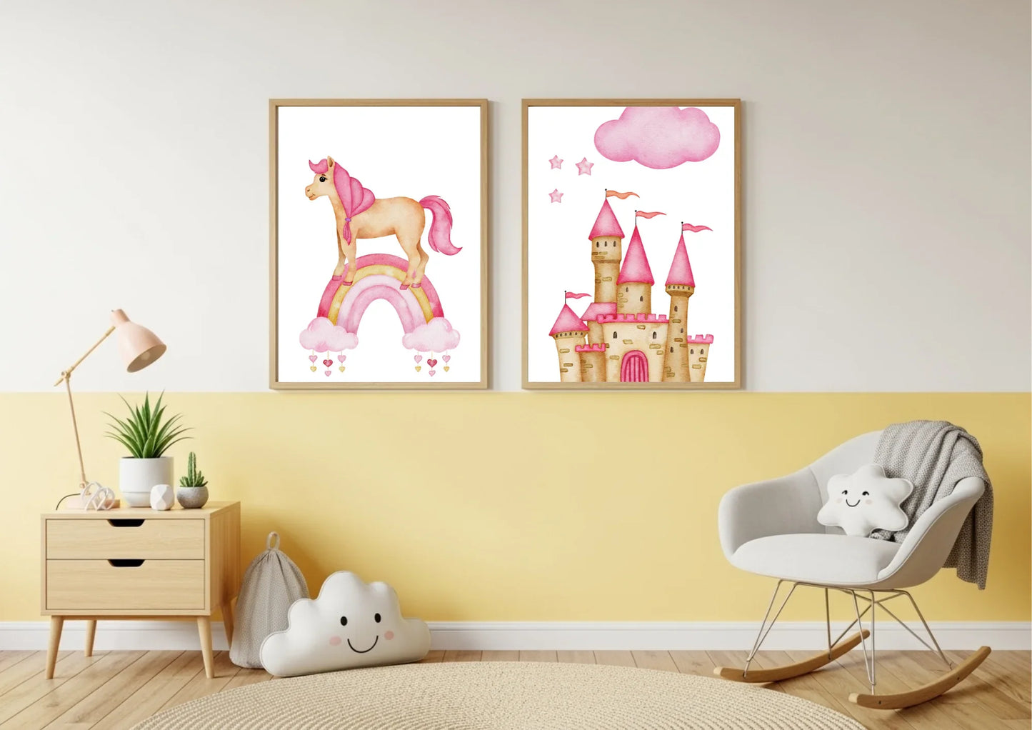 Two framed watercolor prints, one featuring a unicorn on a rainbow and the other a pink princess castle, hang on a wall split between yellow on the bottom and white on the top. To the left is a wooden nightstand with a lamp and a plant. To the right is a white rocking chair with a cloud-shaped pillow.