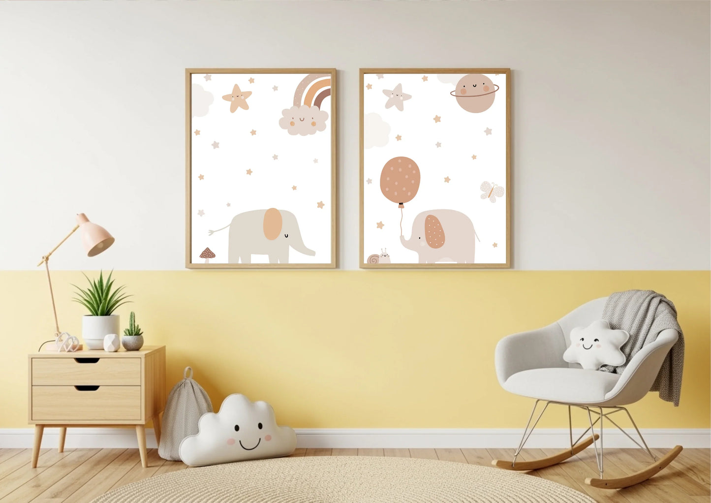 A brightly styled nursery or reading corner with a wall painted white on top and a cheerful yellow below. A set of two framed prints featuring cute elephants, stars, and celestial elements in neutral tones hangs in the center. A wooden nightstand with a pink lamp, a cloud-shaped pillow on the floor, and a white rocking chair with a star pillow are visible.