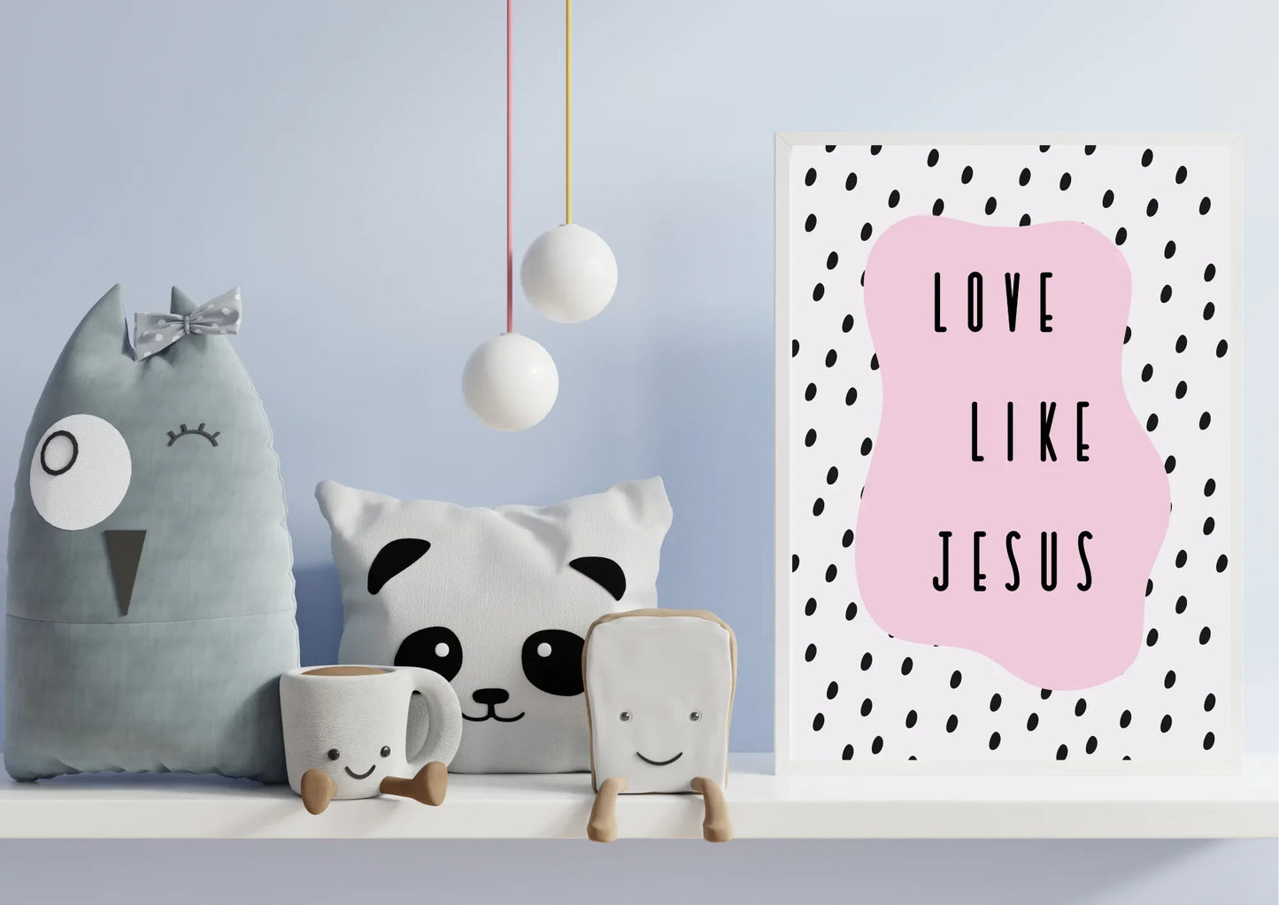 A framed "Love like Jesus" art print on a shelf with plush owl and panda toys in a child's playroom.