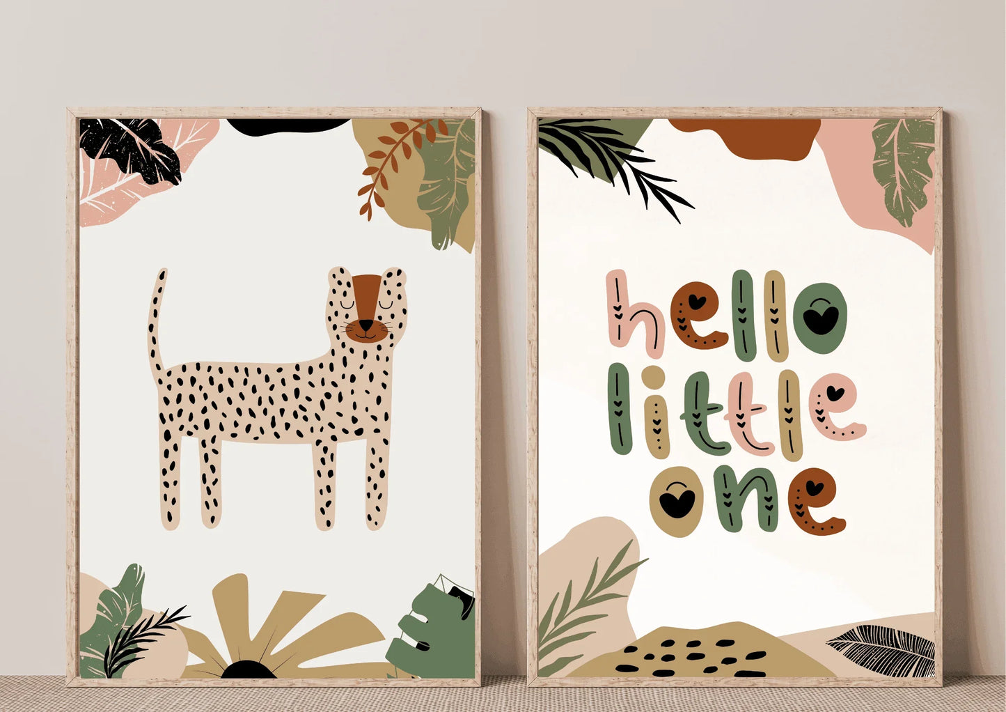 A close-up of a two-piece framed art set with a boho jungle theme, featuring a spotted cheetah/leopard print and the phrase "hello little one" in earthy green and brown tones.