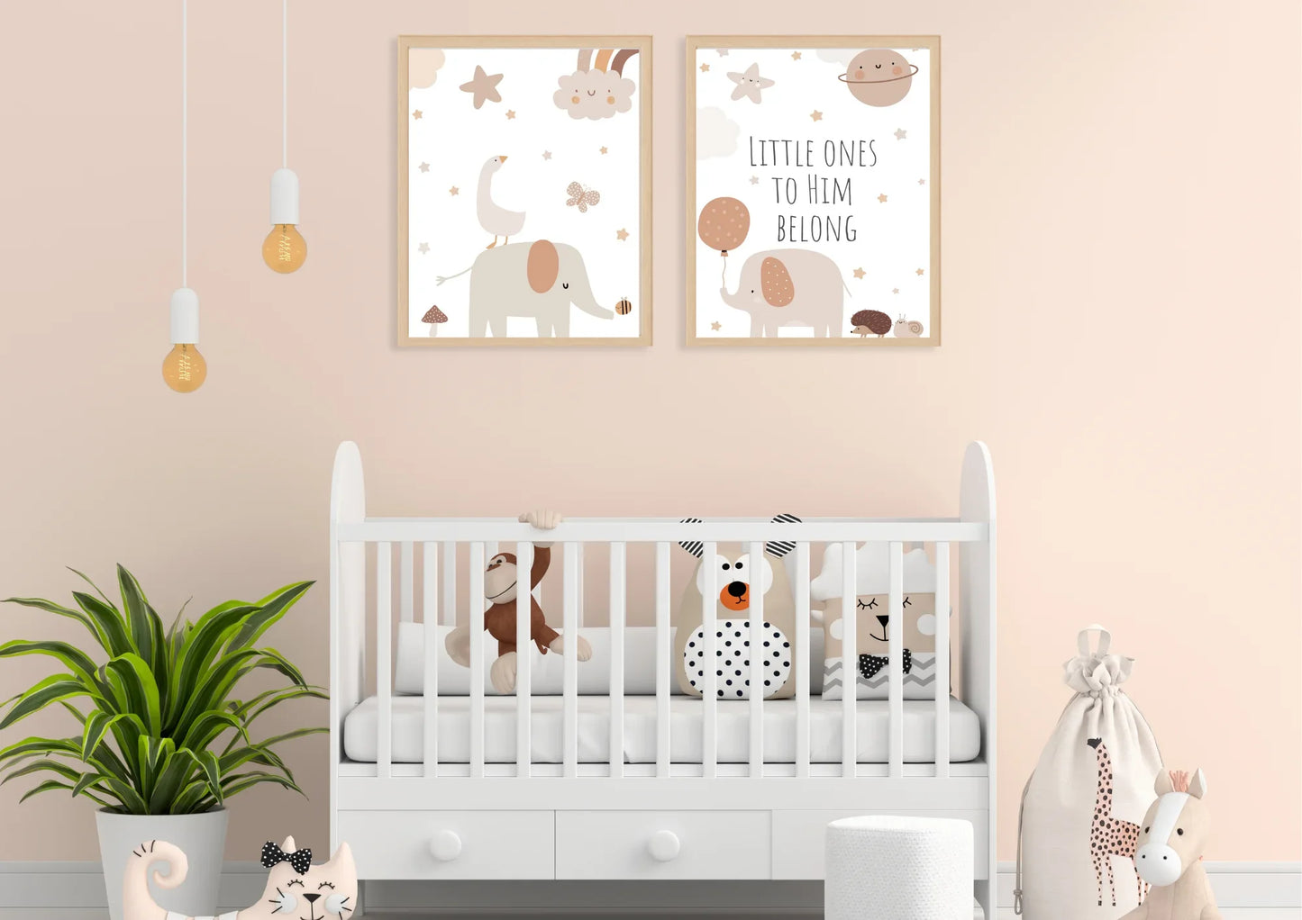 A set of two framed art prints with elephants and the quote "Little ones to him belong" on a peach wall above a white crib.