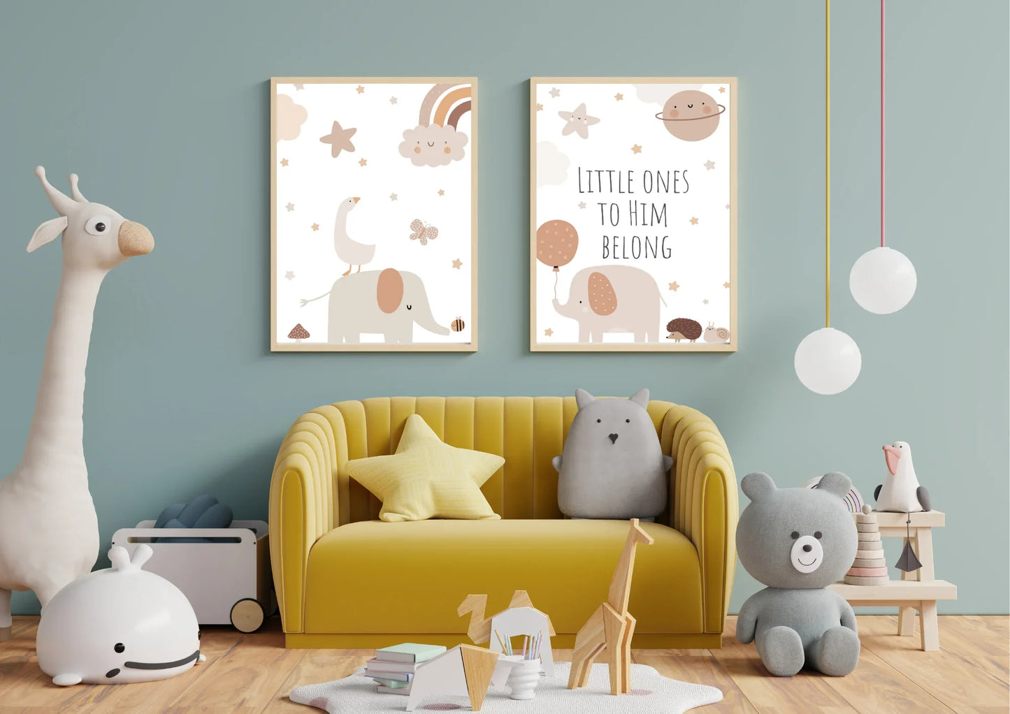 A set of two framed art prints with elephants and the quote "Little ones to him belong" on a blue wall in a child's playroom with a yellow armchair.