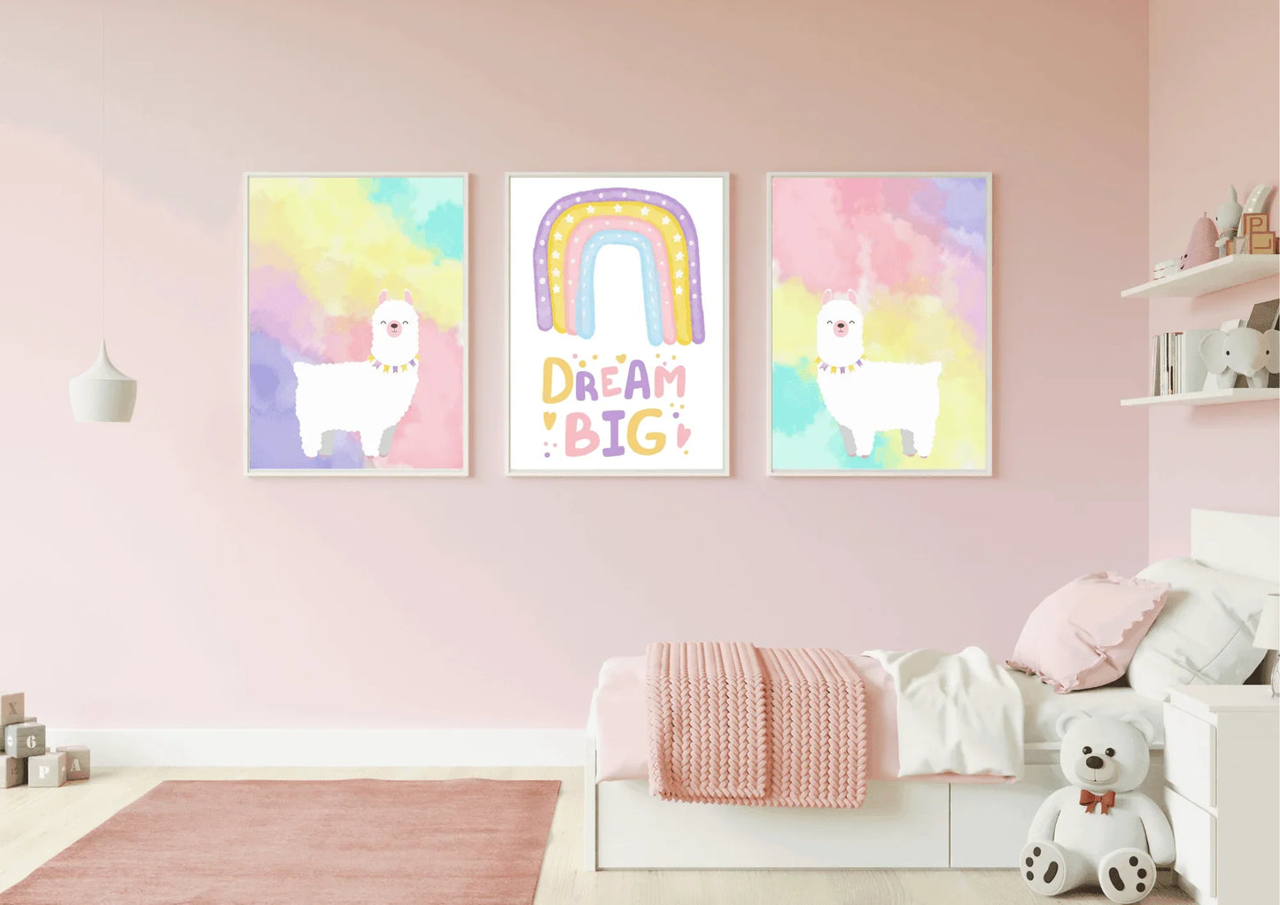 A set of three framed art prints with two llamas and a "Dream Big" quote on a pink wall in a child's bedroom.