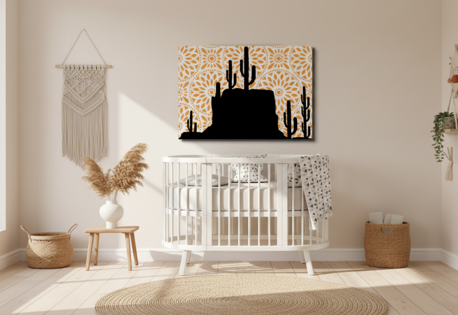  A black cactus silhouette art print with an orange mandala background hangs above a white crib in a modern boho nursery. The room features a woven rug and a macrame wall hanging.