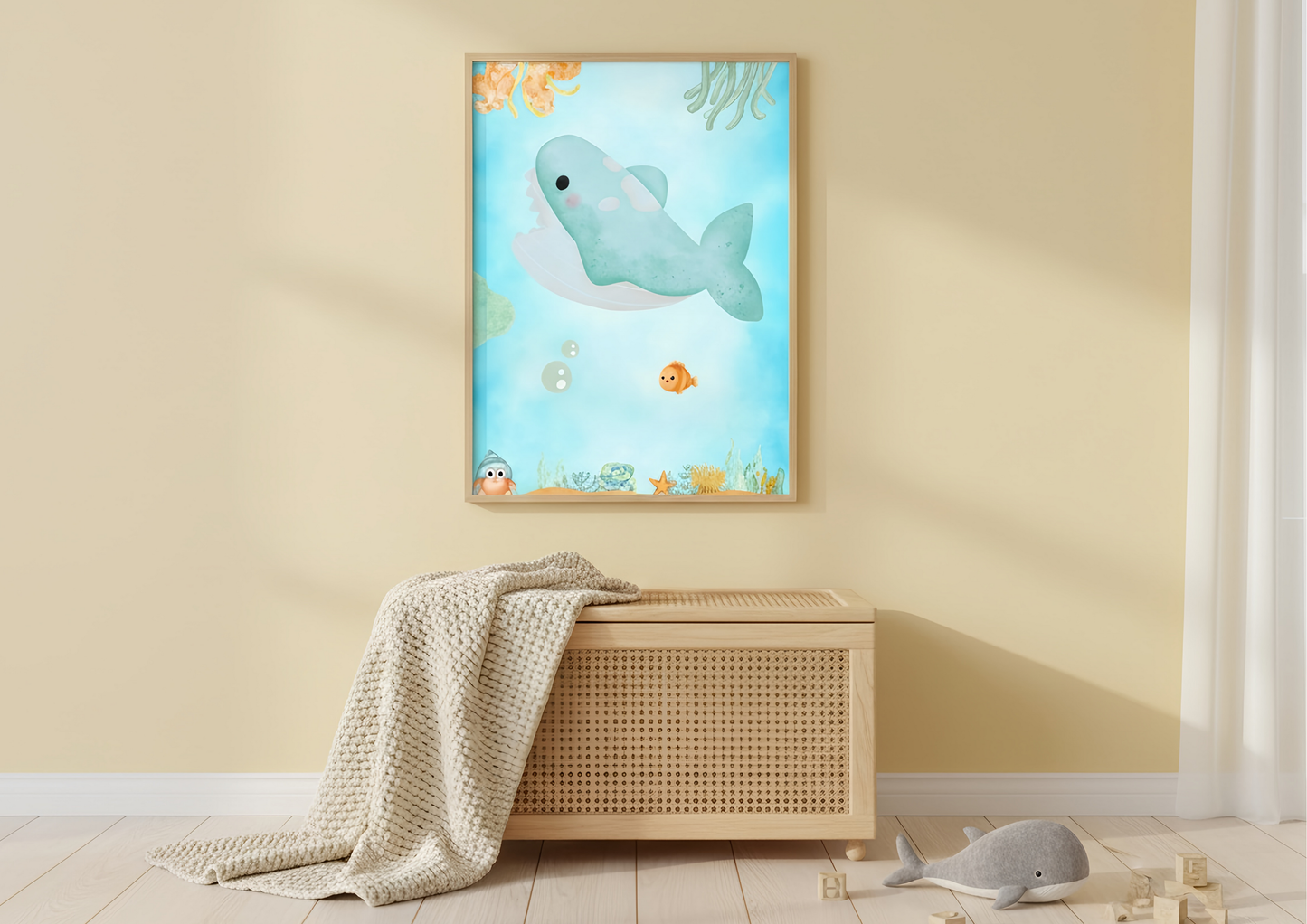 Framed children's poster of a whale on a wall above a wicker chest.