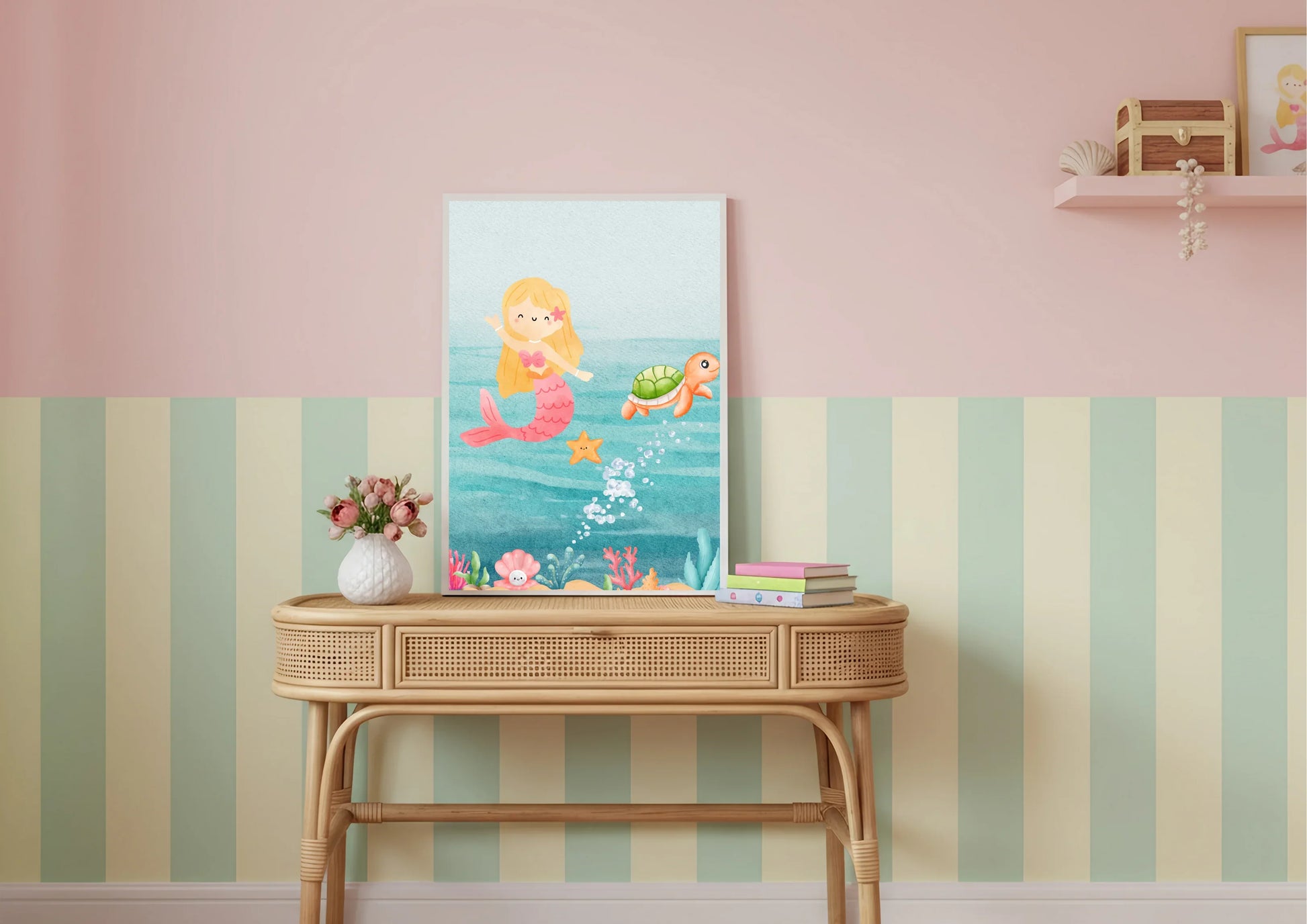 Canvas print of a mermaid and fish on a wall above a wooden console table with striped wallpaper.