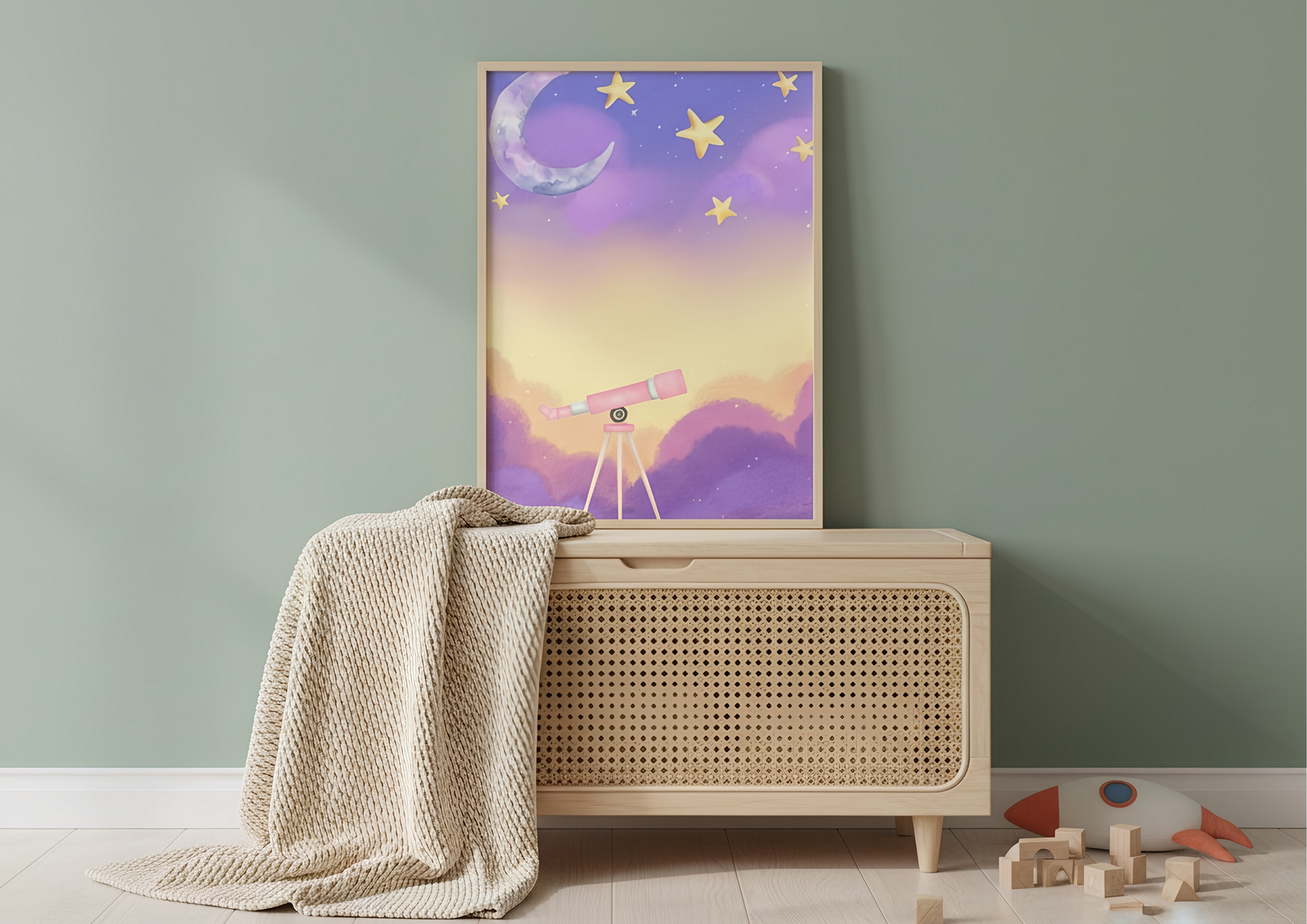 Framed artwork of a celestial scene with a moon, stars, and telescope on a green wall above a wooden cabinet.