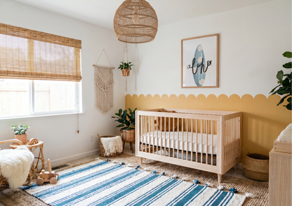 Nursery room with a crib, rug, and decorative elements and surfboard .all art