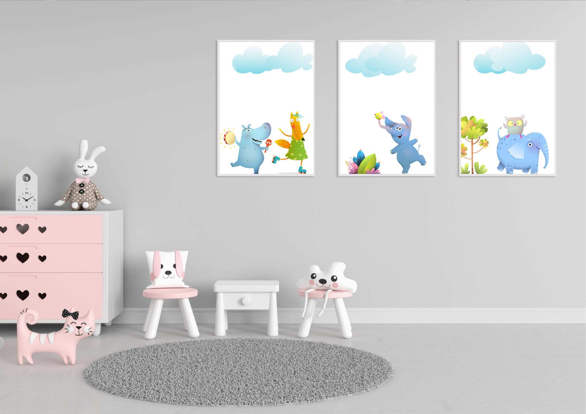 A set of three whimsical animal art prints in white frames on a gray wall in a child's playroom with a pink dresser.