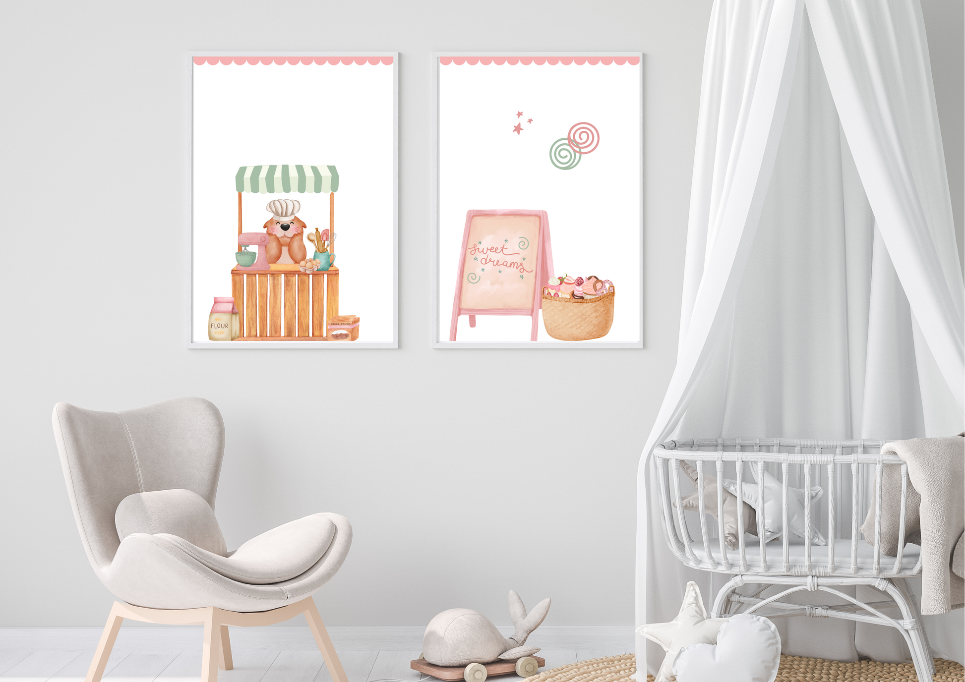 Two vertical nursery prints with pink scalloped borders hanging on a white wall above a modern grey nursery chair. The left print shows a whimsical bear baker at a stall; the right print shows a pink chalkboard and a basket of cupcakes. A white wicker crib with a canopy stands to the right.