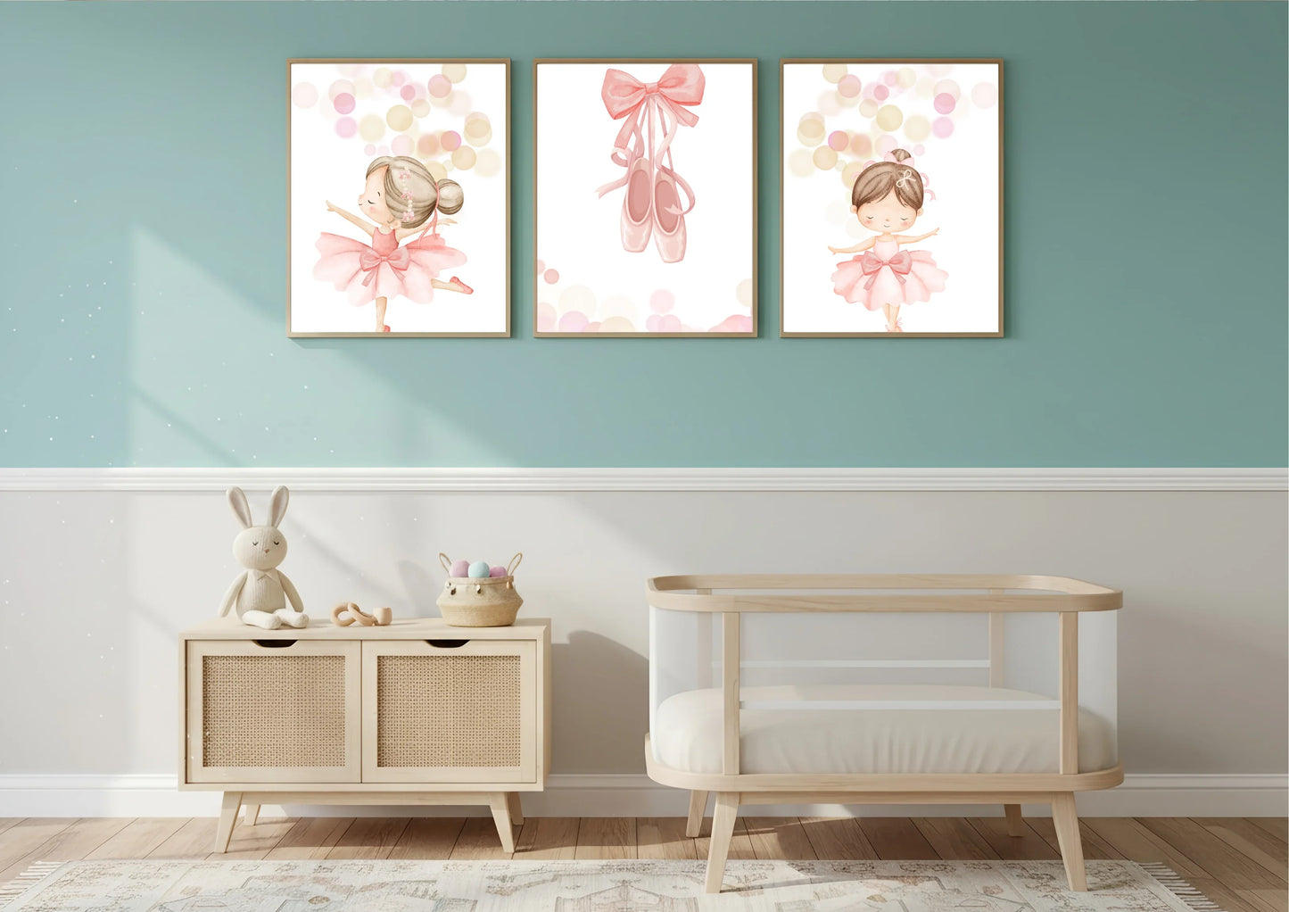 Children's room with wooden crib, side table, and wall art featuring a bow and two ballerinas.