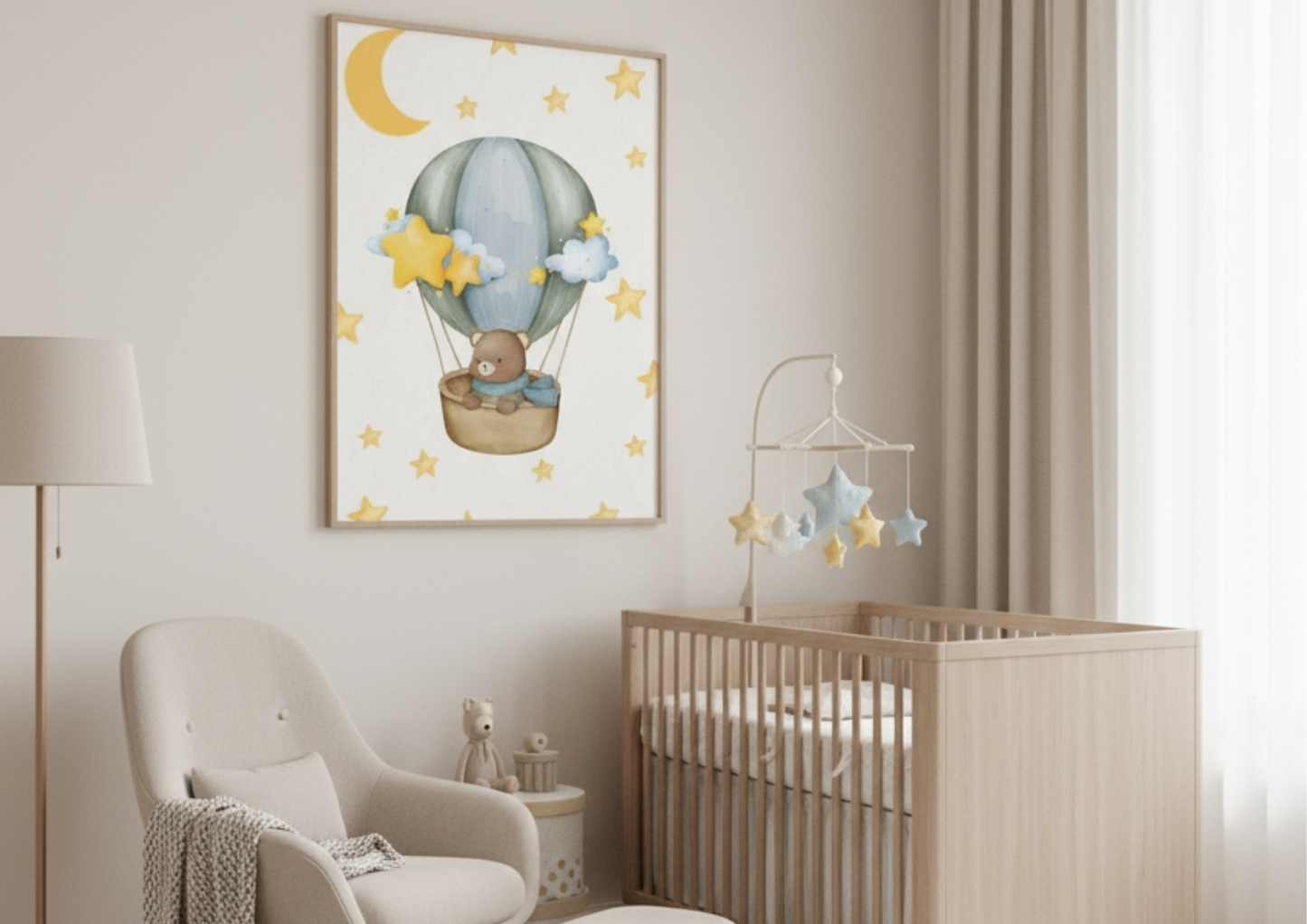 A vertical framed nursery wall art print hanging above a crib and next to a cozy armchair. The artwork features a cute teddy bear in a wicker basket floating in a hot air balloon with a light blue and green canopy, surrounded by yellow stars and crescent moon against a white or cream background. The room itself is decorated in neutral, earthy tones, with a light wood crib, a hanging star mobile, and a beige armchair.