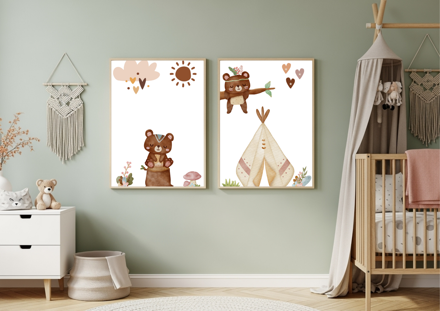 A set of two framed Aztec tribal woodland bear nursery prints hanging on a sage green wall, styled above a crib with a boho canopy and next to a white dresser with a teddy bear and macrame wall hangings.