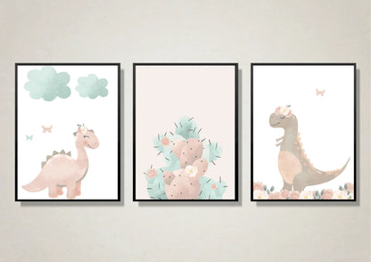 Three framed watercolor prints featuring a pink dinosaur with clouds, a pastel pink and mint cactus, and a floral brown dinosaur.