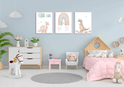 A set of three framed nursery art prints depicting pastel dinosaurs and a rainbow, hanging on a light blue wall above a dresser and a child's bed. The room is decorated in a soft color palette with a rocking horse, a small table and chair, and a fluffy rug.