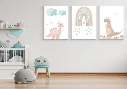 A minimalist child's room with white walls and a light wood floor. A set of three digital art prints featuring pastel dinosaurs and a rainbow hangs on the wall above a crib filled with stuffed animals. A small blue stool with a smiling cloud face and a gray whale-shaped plush toy are on the floor.