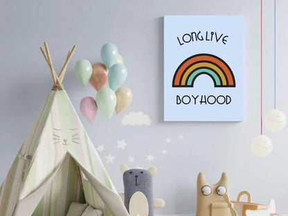 A canvas print of a "Long Live Boyhood" retro rainbow on a light blue wall, hanging above a stuffed toy, a play teepee, and balloons.