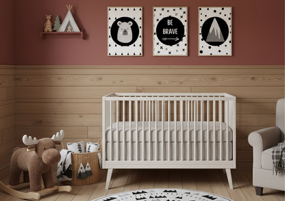 Nursery room with a white crib, stuffed moose, and wall art on a wooden floor.