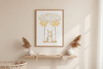 Framed artwork of a rabbit on a swing with balloons above, displayed on a wall above a shelf.