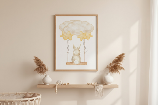 Framed artwork of a rabbit on a swing with balloons above, displayed on a wall above a shelf.