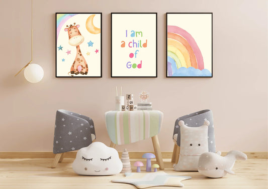 A three-piece framed nursery print set, featuring a giraffe, a "Child of God" message, and a rainbow, hanging on a light beige wall above a small table and children's chairs.