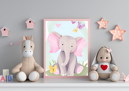 A framed digital art print of a baby elephant with pink ears and butterflies, leaning against a gray wall on a white shelf. A light brown horse plush toy is on the left, and a beige stuffed rabbit with a red heart on its chest is on the right. Pink star-shaped lights are hanging on the wall.
