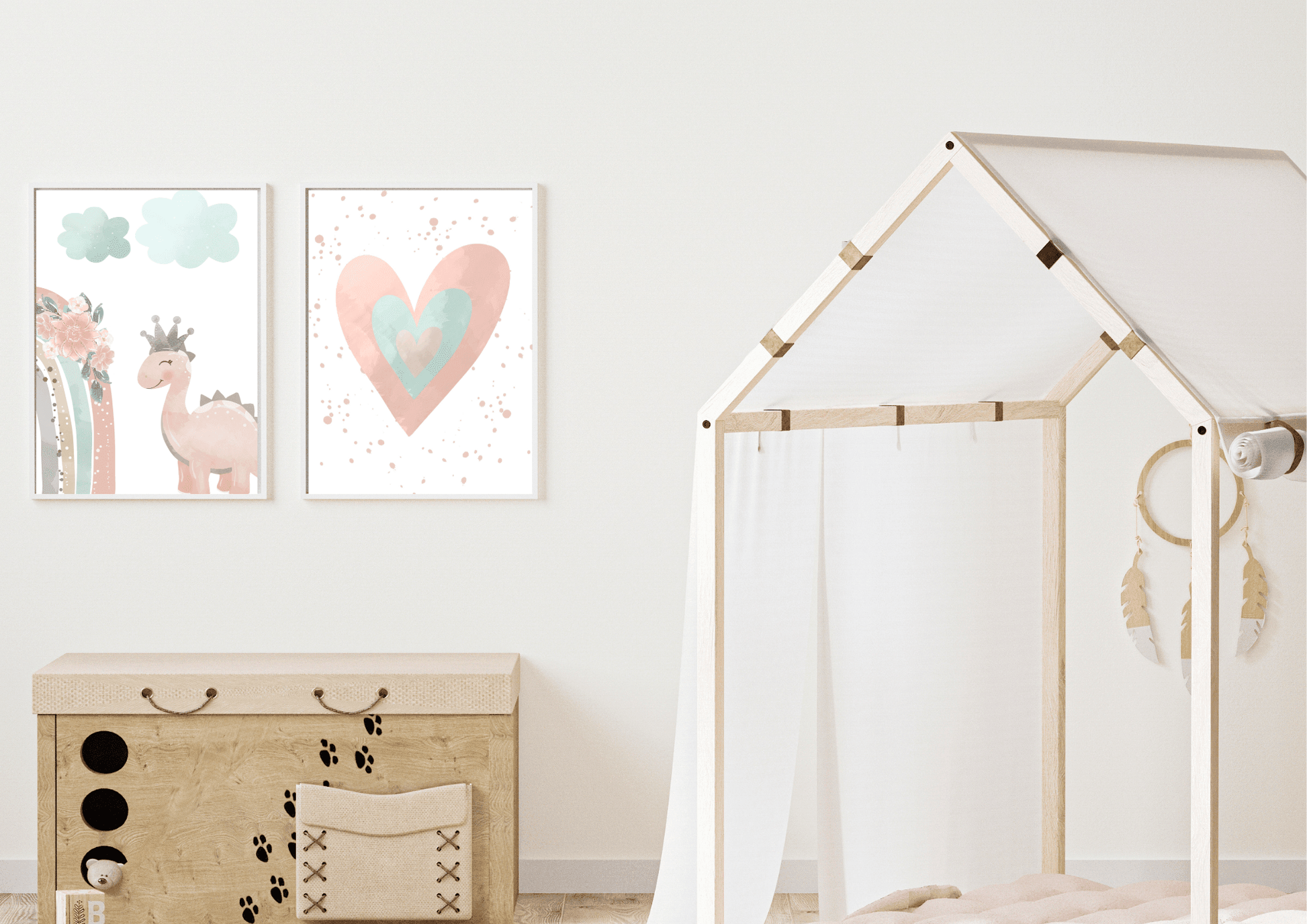 A close-up of a playful kids' room featuring a wooden toy chest with paw prints and a teepee bed frame. Above the toy chest, two framed prints show a cute pink dinosaur with a crown and a watercolor heart, adding a whimsical touch to the space.