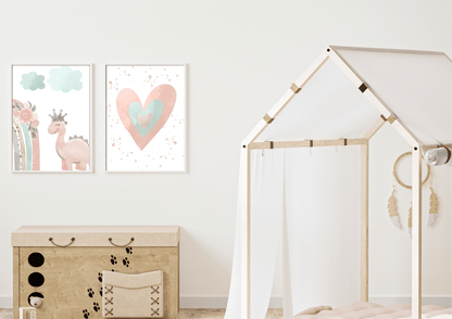 A close-up of a playful kids' room featuring a wooden toy chest with paw prints and a teepee bed frame. Above the toy chest, two framed prints show a cute pink dinosaur with a crown and a watercolor heart, adding a whimsical touch to the space.