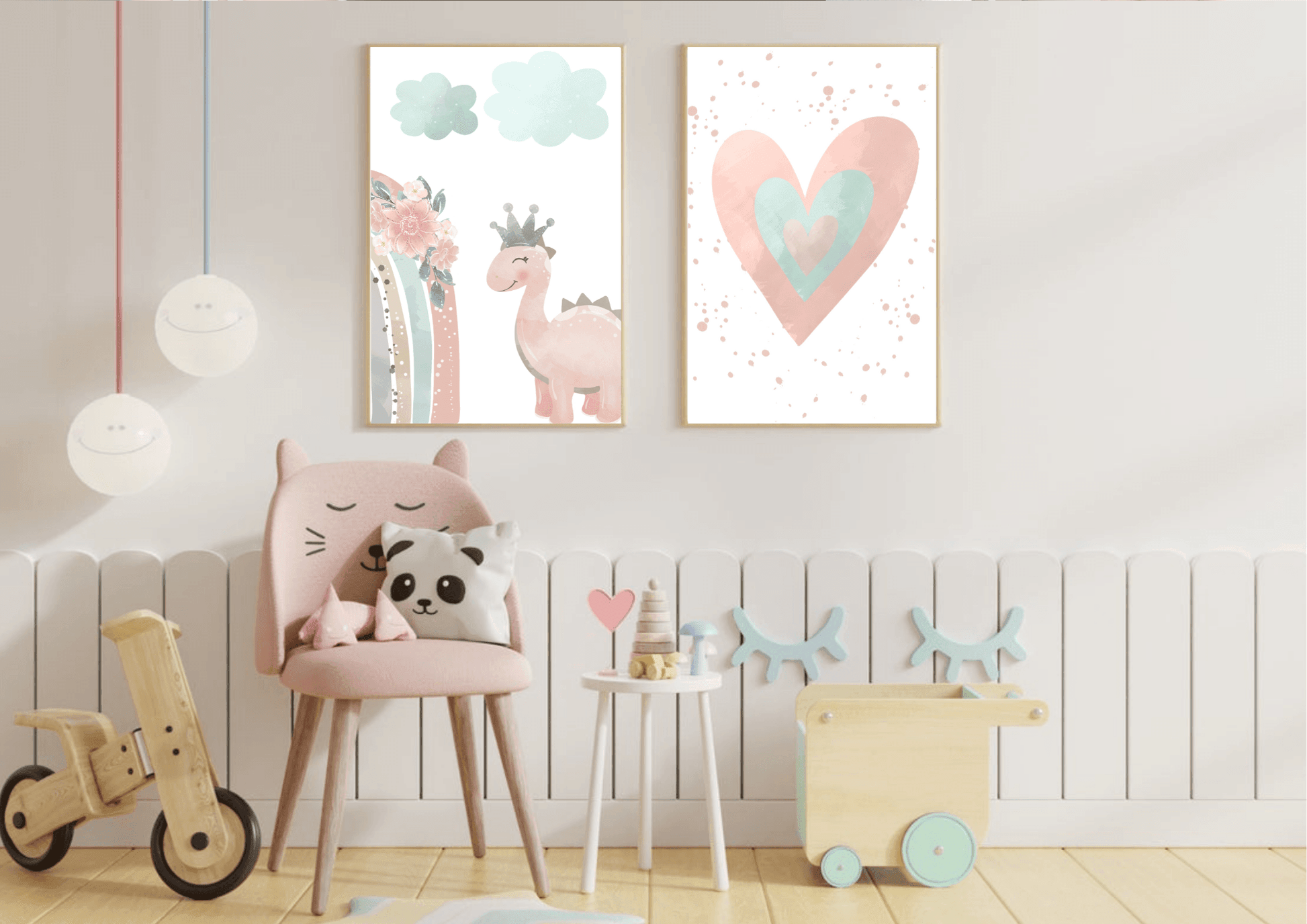 A whimsical kids' room with a white vertical plank wall. Two framed prints hang above a small pink chair with cat ears, depicting a watercolor heart and a cute pink dinosaur with a crown. The room also includes various wooden toys, a small side table, and unique hanging lights, creating a fun and stylish space.