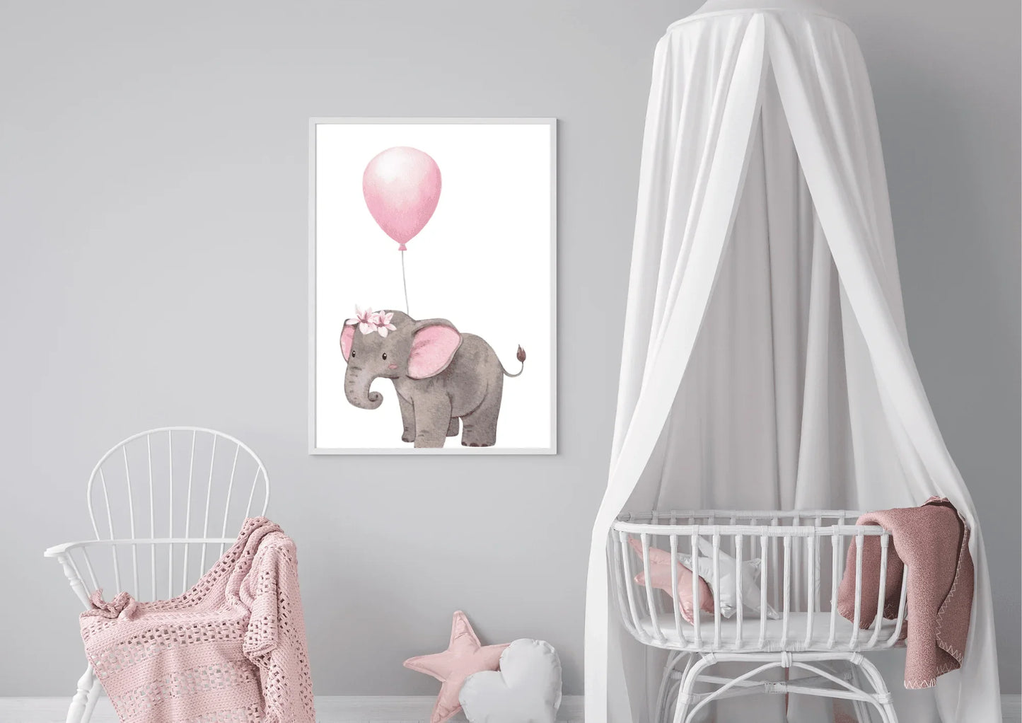 A framed nursery print of a baby elephant holding a pink balloon, hanging on a gray wall between a white rocking chair and a crib with a canopy.