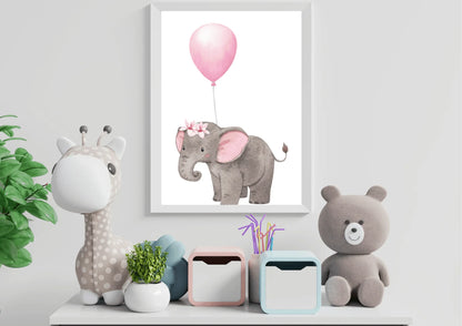 A framed nursery print of a baby elephant with a floral crown holding a pink balloon, standing on a white shelf next to a stuffed giraffe, a teddy bear, and a small planter.