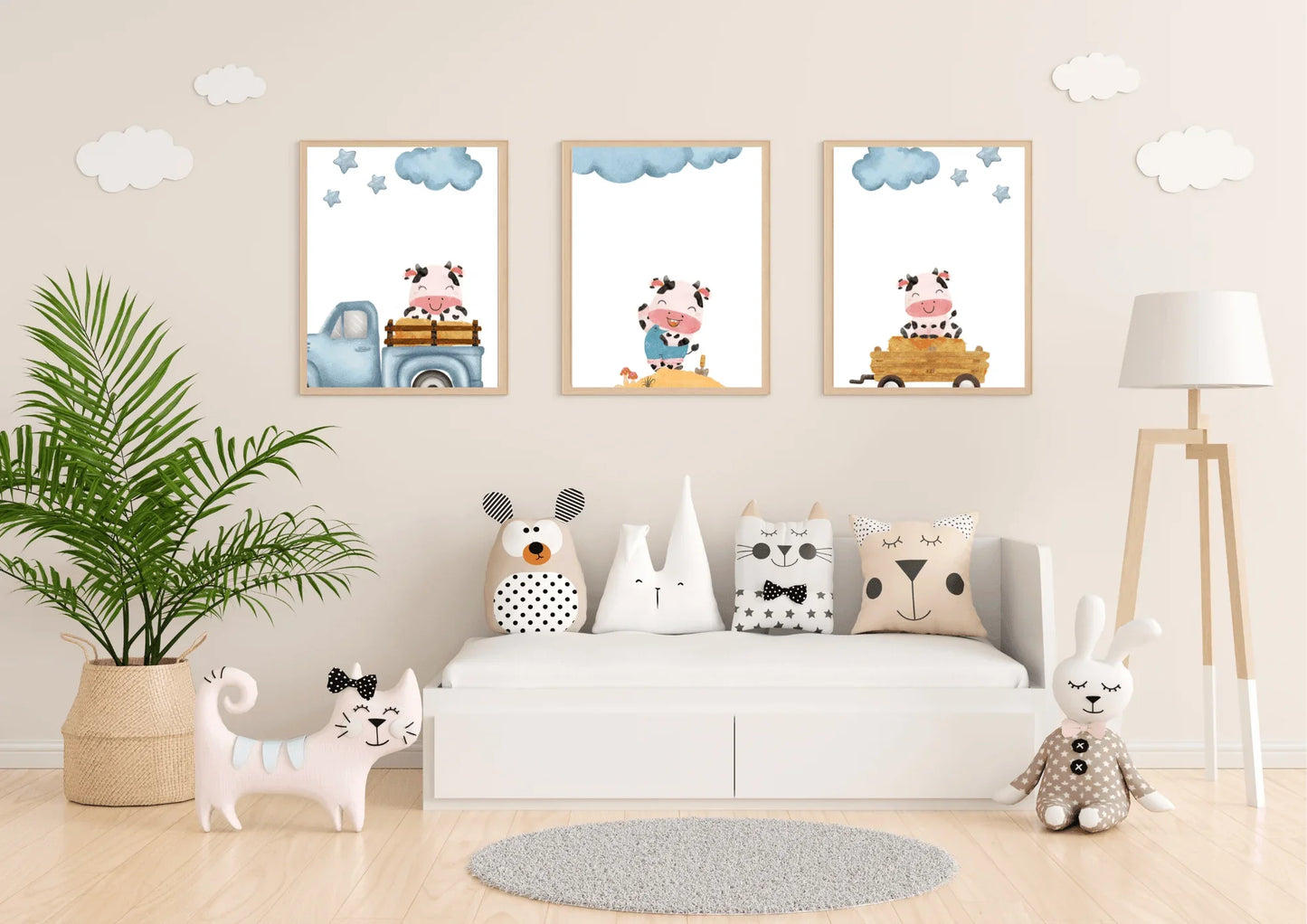 Three framed Farm Cow Nursery Art prints displayed above a low white toy bench in a light, neutral-toned playroom.