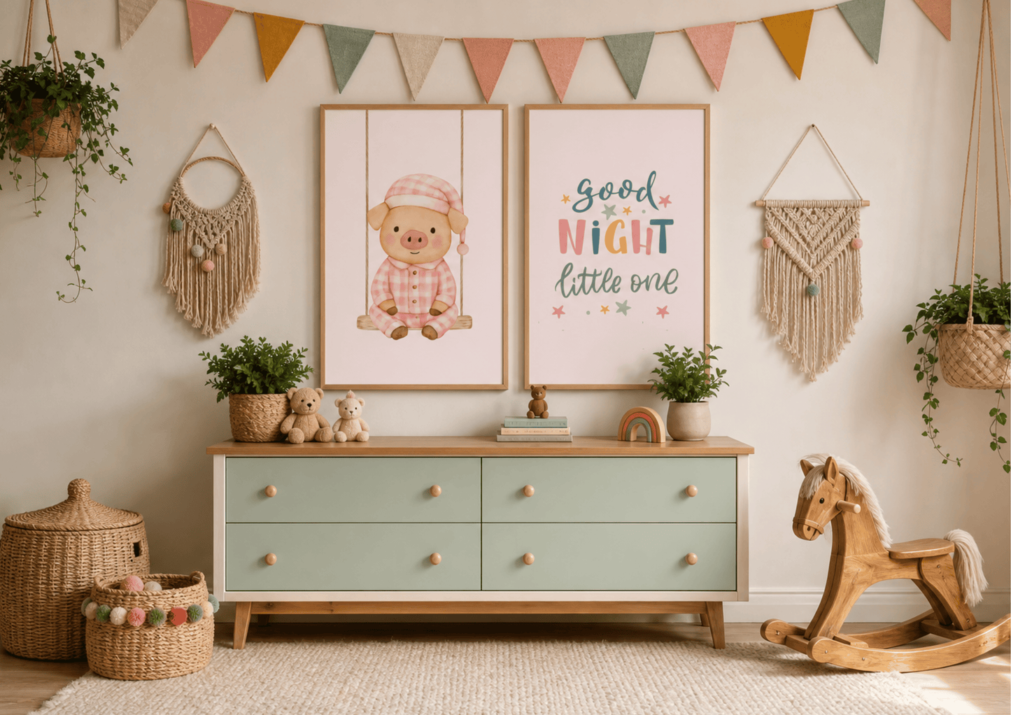 A styled nursery interior featuring two framed wall art prints above a mint green and wood dresser. The left print shows a cartoon pig in a pink hat, and the right print reads 'good NIGHT little one' in colorful lettering.