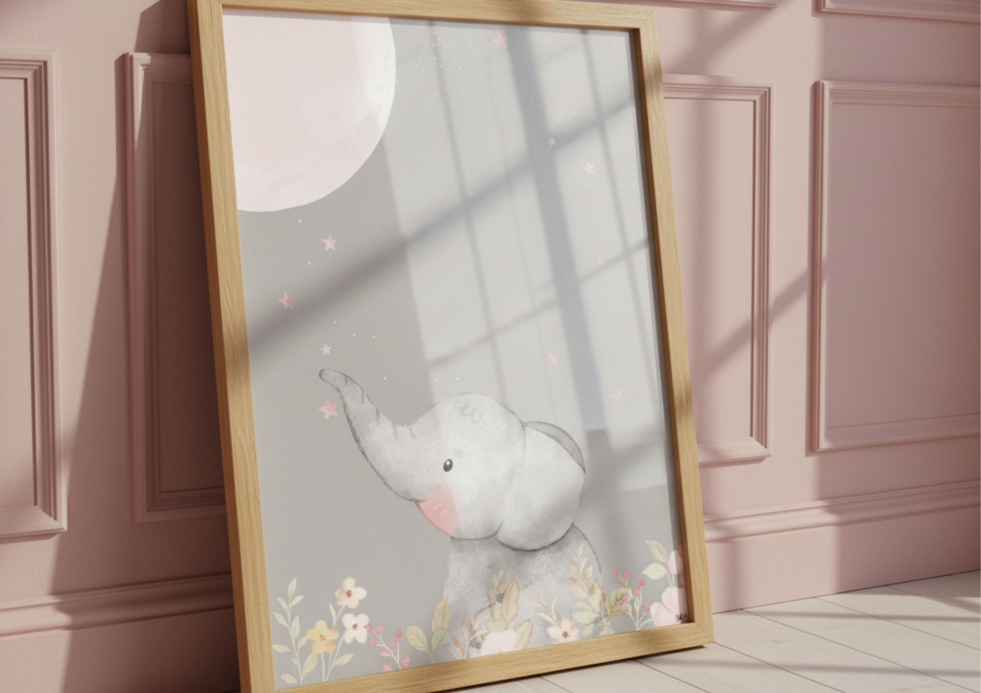 Framed artwork of a cartoon elephant and moon resting a pink wall