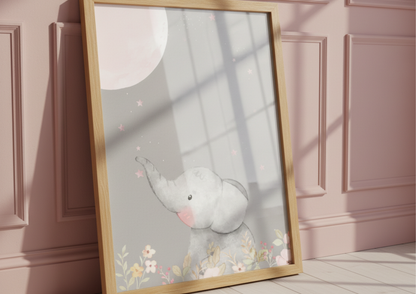 Framed artwork of a cartoon elephant and moon resting a pink wall
