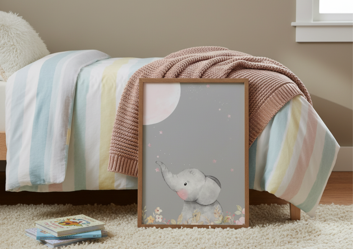 Large framed picture of an elephant resting in front of a bed and colorful blanket in the background