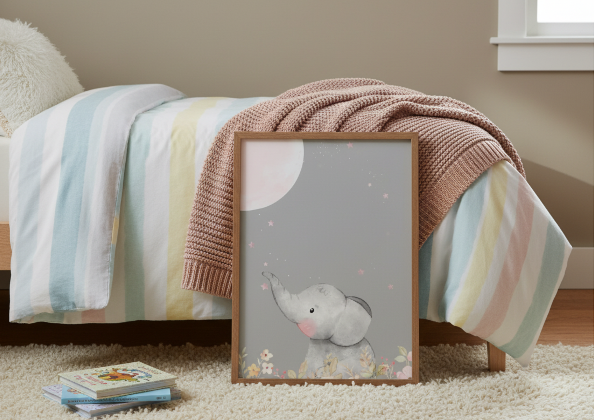 Large framed picture of an elephant resting in front of a bed and colorful blanket in the background
