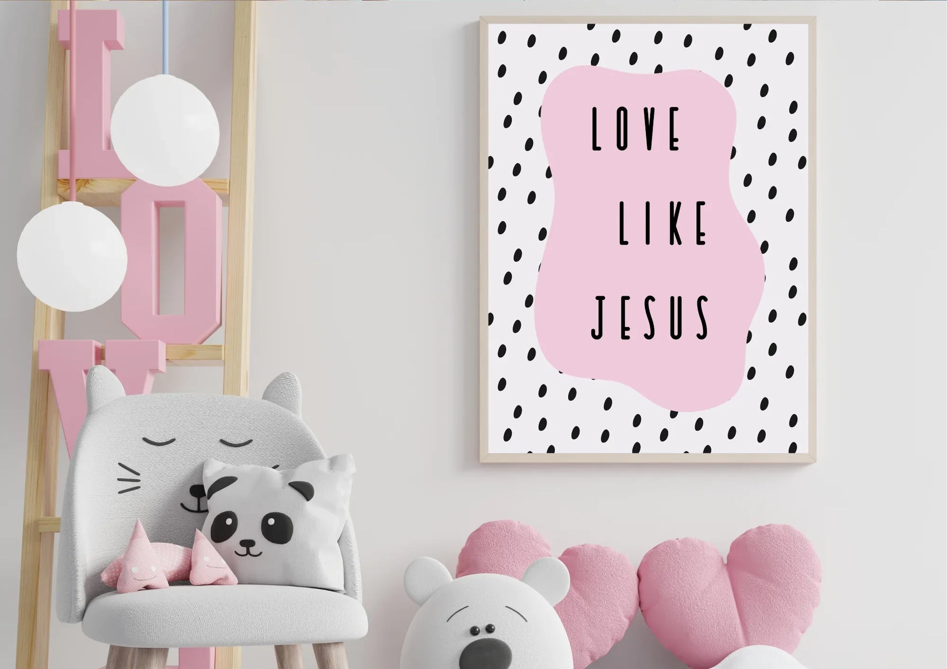 A wooden-framed art print with the quote "Love like Jesus" on a white wall in a child's room with a cat chair and a "LOVE" sign.
