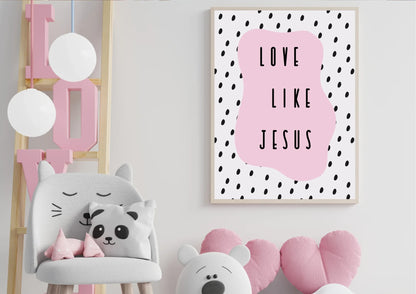 A wooden-framed art print with the quote "Love like Jesus" on a white wall in a child's room with a cat chair and a "LOVE" sign.