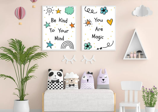 A pair of framed digital art prints with whimsical doodles and positive affirmations, hanging on a light pink wall. The left print says "Be Kind To Your Mind" and the right one says "You Are Magic." Below the prints, a small white bench holds four animal-shaped pillows.