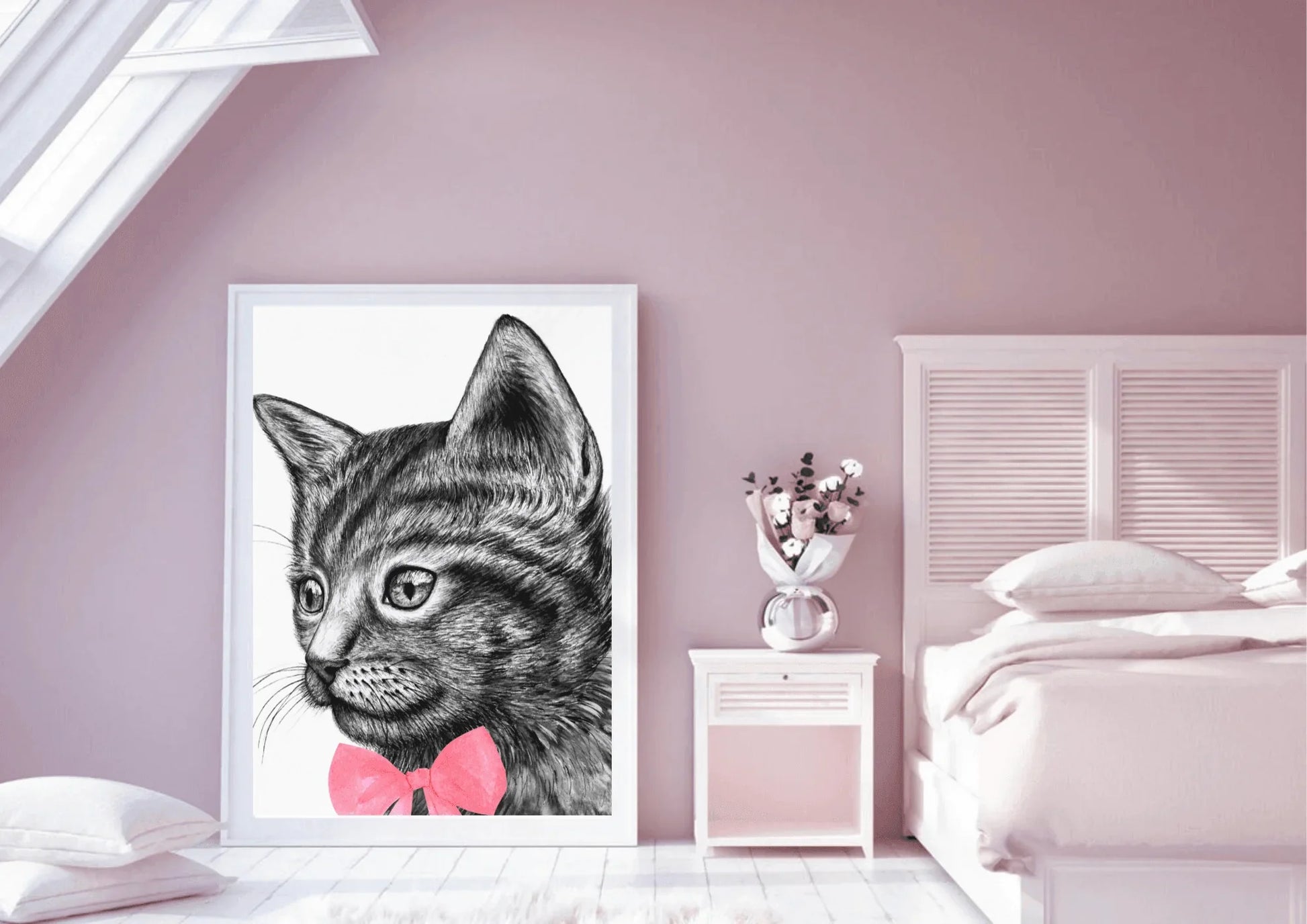 A framed digital art print of a black and white cat with a pink bow tie, leaning against a wall in a pink-walled bedroom with a bed and a white nightstand with a vase of flowers on it.