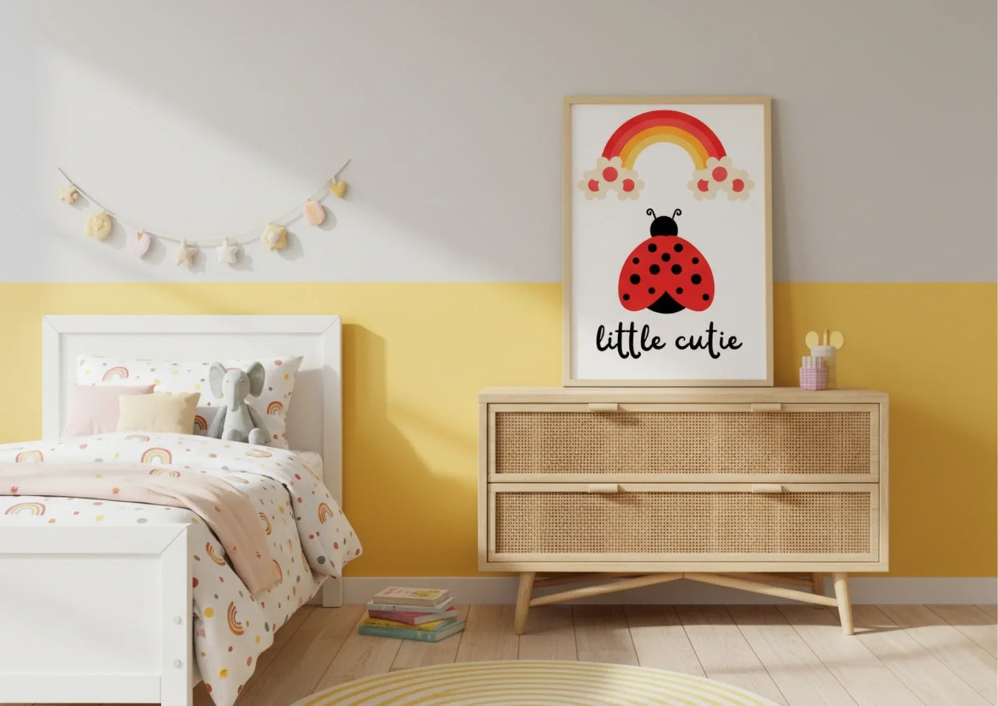Children's bedroom with a dresser, bed, and wall art featuring a ladybug and rainbow.