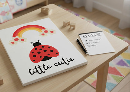 Children's wall art with a ladybug and rainbow on a wooden table.