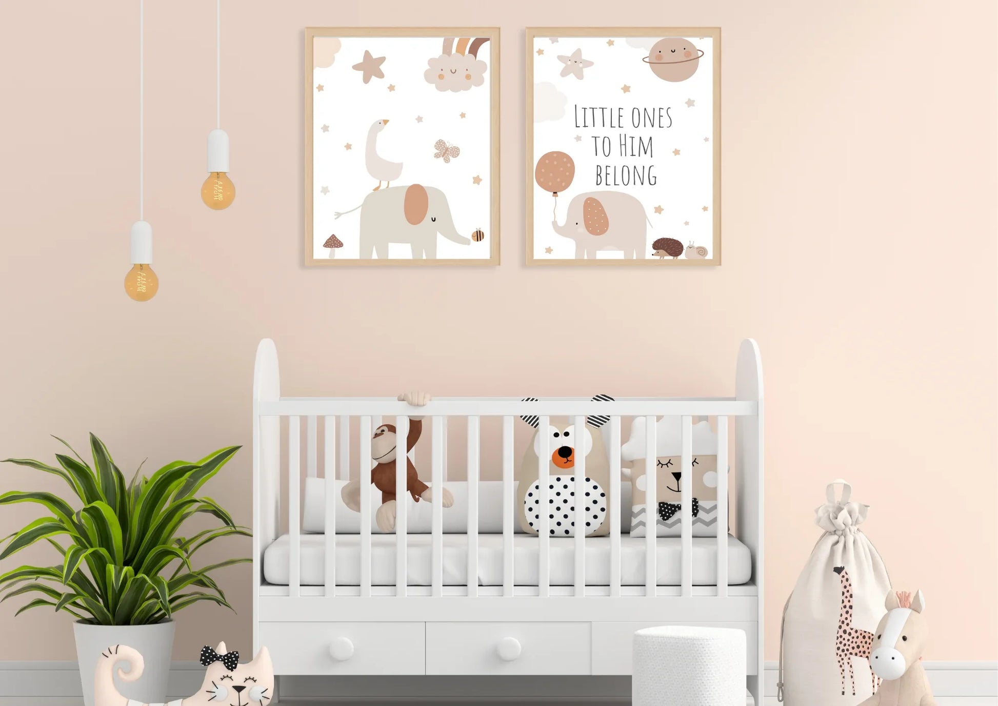 A set of two framed art prints with elephants and the quote "Little ones to him belong" on a peach wall above a white crib.