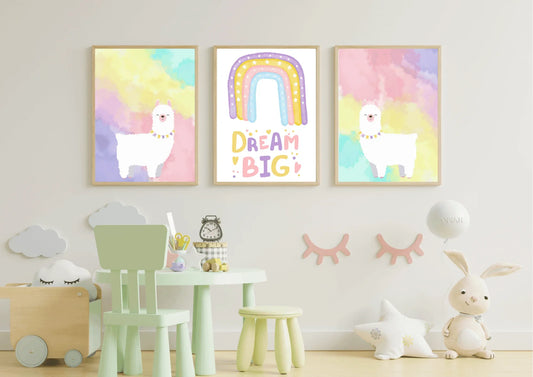 A set of three framed art prints with two llamas and a "Dream Big" quote on a white wall in a playroom with a mint green table and chair.