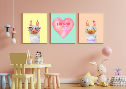 A close-up view of a child's playroom with pastel pink walls, featuring three framed llama and heart prints. Below the art is a small yellow and wooden play table with a yellow chair and pink stool. Various toys, including a large white stuffed bunny and a pink balloon, are visible on the floor.