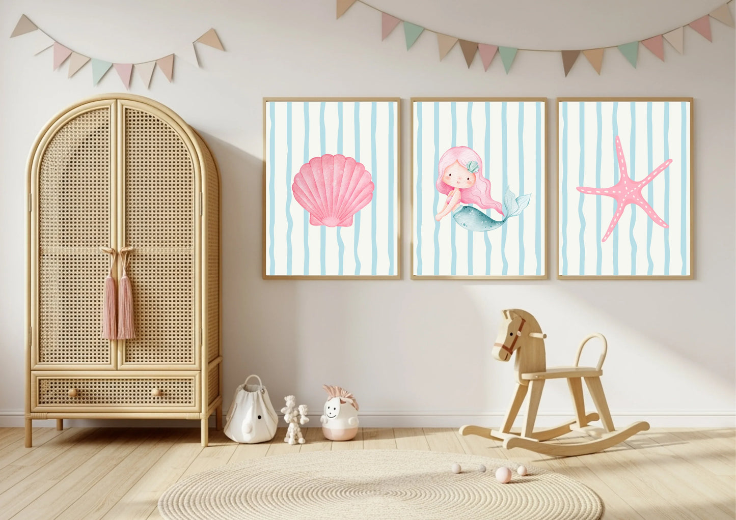 Children's room with a rattan armoire, rocking horse, and wall art featuring a mermaid and starfish.