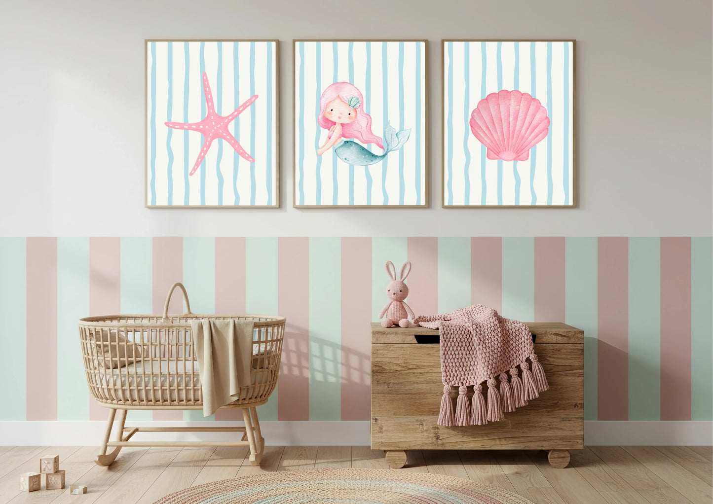 Nursery room with wall art featuring a mermaid, starfish, and shell on a striped background.